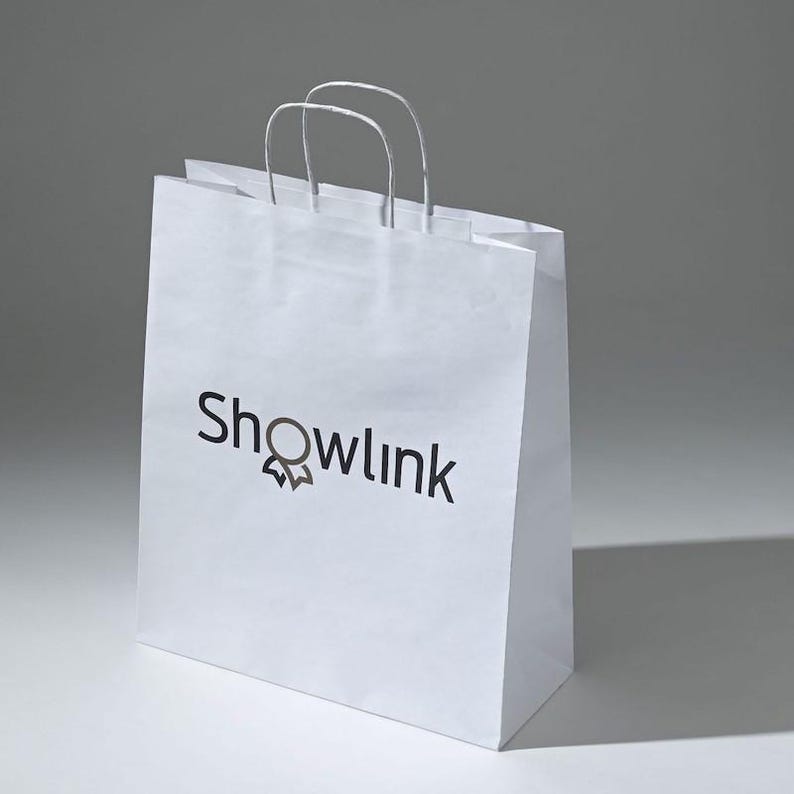 May include: White paper shopping bag with a black logo that says "Showlink" and a stylized ribbon design.