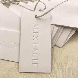 May include: White rectangular hang tag with the text "ALEX EAGLE" embossed in a white font.
