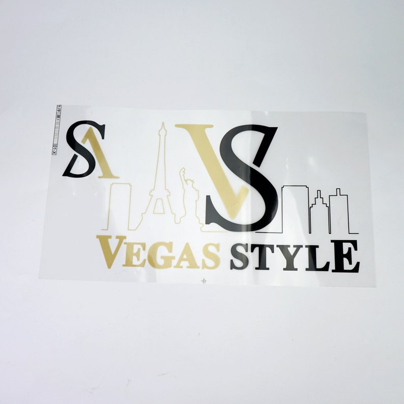 K&ouml;nnte beinhalten: Ein schwarzes und goldenes Grafikdesign mit dem Text "Vegas Style" und Bildern vom Eiffelturm, der Freiheitsstatue und einer Skyline.