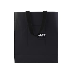 以下が含まれることがあります： 長方形の黒いショッピングバッグ。黒いハンドルが付いています。バッグには白い文字で「GGVV」と「Glamour Gentlemen Vegan Vintage」の文字が書かれています。バッグはマットな素材で作られています。