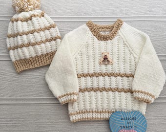 Puede incluir: Conjunto de jersey y gorro de punto color crema para bebé. El jersey presenta un pequeño aplique de oso de peluche y ribetes marrones. El gorro tiene un pompón. Hecho a mano, para bebé.