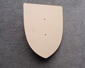 May include: A plain, light brown wooden shield with two small holes in the centre.
