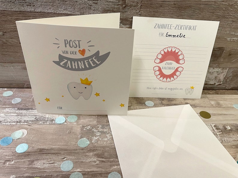 Może przedstawiać: Certyfikat wr&oacute;żki zębuszki z r&oacute;żowo-białą ilustracją ust z zębami. Certyfikat jest dla Emmelie i ma miejsce na śledzenie utraconych zęb&oacute;w.
