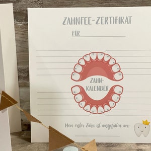 Może przedstawiać: Biała, drukowalna karta z szarym tytułem "Zahnfee-Zertifikat" i linią na wpisanie imienia. Karta zawiera r&oacute;żowo-białą ilustrację ust z zębami i tekstem "Zahn-Kalender". Pod ilustracją znajduje się tekst "Mein erster Zahn ist ausgefallen am:" i miejsce na wpisanie daty. Biały ząb z złotą koroną i uśmiechającą się twarzą znajduje się w prawym dolnym rogu.