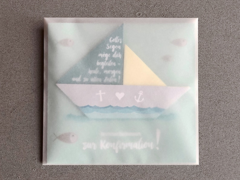 May include: A light blue and white card with a paper sailboat design. The card has the text "Gottes Segen m&ouml;ge dich begleiten - heute, morgen und in allen Zeiten!" and "zur Konfirmation!"