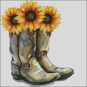 Könnte beinhalten: Ein Paar braune Cowboy-Stiefel mit Sonnenblumen darauf. Die Stiefel sind abgenutzt und haben einen Used-Look. Die Sonnenblumen sind gelb mit braunen Zentren.