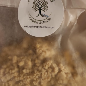 May include: A clear plastic bag containing beige, granular wax pieces. A circular white label is attached to the top, featuring a black tree graphic, the text Nature Therapy Candles & Media, and the website address naturetherapycandles.com.