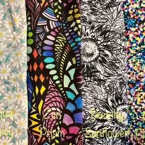 May include: Four fabric swatches with different patterns. The first swatch is a light blue fabric with a white daisy pattern. The second swatch is a black fabric with a colorful abstract pattern. The third swatch is a white fabric with a black and white sunflower pattern. The fourth swatch is a dark blue fabric with a colorful confetti pattern.