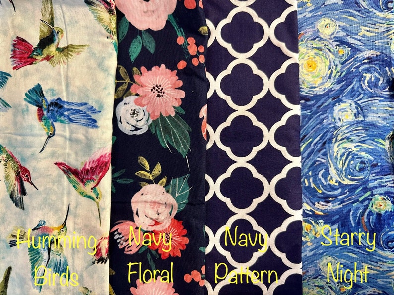 May include: Four fabric swatches with different patterns. The first swatch features a white background with colorful hummingbirds. The second swatch has a navy blue background with a pink and green floral pattern. The third swatch has a navy blue background with a white geometric pattern. The fourth swatch has a blue background with a swirling, yellow, and white pattern reminiscent of Van Gogh's Starry Night.