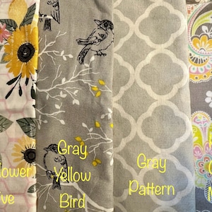 May include: Four fabric swatches with different patterns and colors. The first swatch is a white background with a pink and yellow sunflower pattern and the text "Sunflower Hive". The second swatch is a gray background with a black bird and branches and the text "Gray Yellow Bird". The third swatch is a gray background with a white geometric pattern and the text "Gray Pattern". The fourth swatch is a gray background with a pink, yellow, and green floral pattern and the text "Pink Gray Multi".