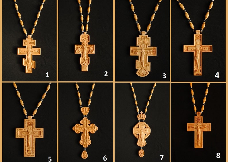May include: Eight wooden crosses with intricate carvings, each on a beaded chain. The crosses feature various religious symbols and figures, including a crucifix and a crown.