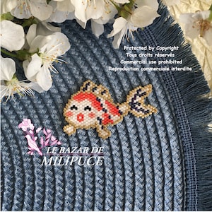 May include: A beaded goldfish charm with red, orange, white and gold details. The charm is on a blue and white woven background. The text "LE BAZAR DE MILIPUCE" is below the charm. The text "Protected by Copyright Tous droits réservés Commercial use prohibited Reproduction commerciale interdite" is above the charm.