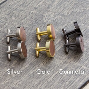 Puede incluir: Tres pares de gemelos con detalles de madera. Los gemelos son de plata, oro y metal gris.