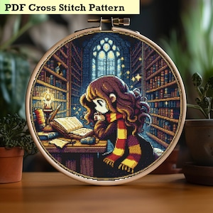 May include: A cross stitch pattern featuring a girl reading a book in a library setting. The girl has long brown hair and is wearing a red and yellow scarf. The library is filled with bookshelves and a large window. The pattern is in a round hoop.