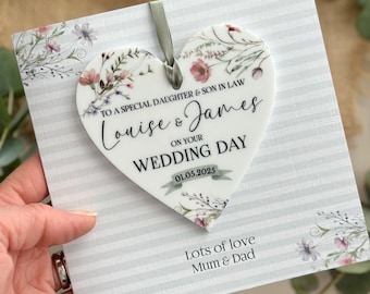 Pode incluir: Adorno de cerâmica branca em forma de coração com um design floral e o texto "To a special daughter & son in law Louise & James on your wedding day 01.05.2025" e "Lots of love Mum & Dad".