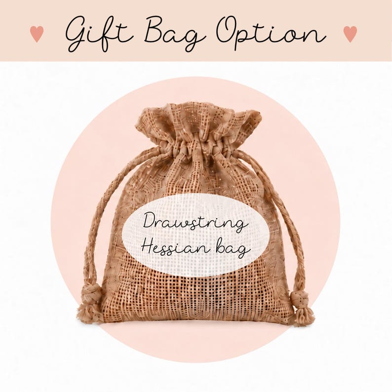May include: A tan drawstring hessian bag with a woven texture. The text Gift Bag Option appears at the top, and the text Drawstring Hessian bag is centered on the front of the bag. The bag features two knotted pull cords at the top opening.