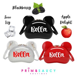 Puede incluir: Tres bolsos tem&aacute;ticos de Minnie Mouse con acabados en negro, plateado y rojo. Cada bolso tiene una etiqueta con el nombre "Bella". Los bolsos se muestran sobre un fondo blanco con texto que dice "Soooo Icy", "Blackberry", "Apple Delight" y "Prim & Saucy Boutique".