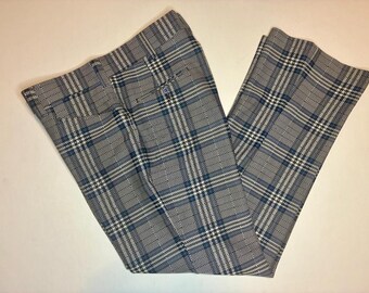 Könnte beinhalten: Eine Hose mit einem blau-schwarz-weißen Karomuster und einer Fischgrätstruktur. Die Hose verfügt über einen Bund mit Gürtelschlaufen, einen Knopfverschluss vorne und ein sichtbares Taschendetail im oberen vorderen Bereich des Kleidungsstücks.