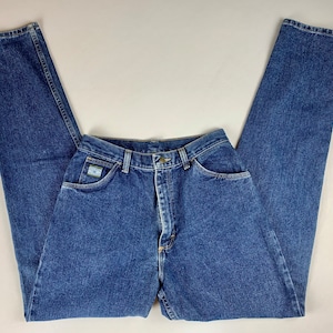 May include: A pair of high-waisted blue denim jeans with a light blue patch on the right pocket that says "Wrangler".