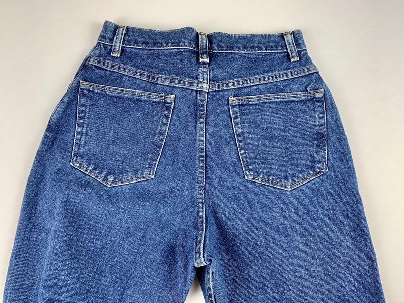 May include: A pair of blue denim jeans with two back pockets.
