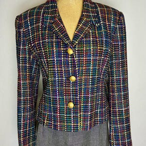 May include: A multi-colored plaid blazer with gold buttons. The jacket features a classic collar and is displayed on a mannequin. The plaid pattern includes shades of blue, green, red, and white.