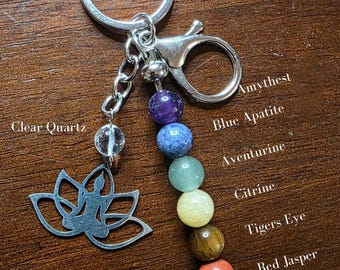 May include: A silver-toned keychain featuring a lotus flower charm and a series of colorful gemstone beads. The beads include amethyst, blue apatite, aventurine, citrine, tiger's eye, and red jasper. The keychain also has a clear quartz bead.