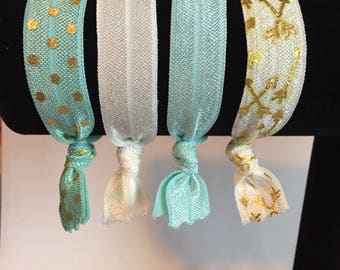 Set of four elastic bracelets/hair ties