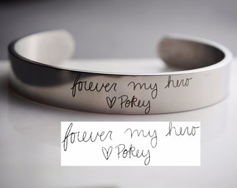 May include: A silver bracelet with the inscription "forever my hero ♥ POKEY" engraved on it.