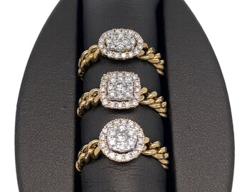 May include: Three gold rings with a square and round diamond cluster design on a black velvet ring display stand.