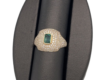 May include: A gold ring with a large emerald green gemstone surrounded by smaller diamonds.