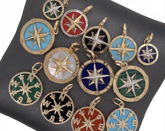 Könnte beinhalten: Eine Sammlung goldfarbener Kompass-Anhänger-Halsketten mit verschiedenen farbigen Emaille- und Edelstein-Inlays. Die Anhänger zeigen ein Sterndesign und Richtungsmarkierungen mit einer Vielzahl von Farben wie Türkis, Rot und Grün.