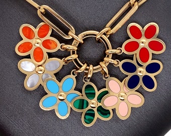 May include: A gold chain necklace with a circular charm featuring six flower charms. The flowers are in various colors, including red, blue, green, pink, orange, and white.