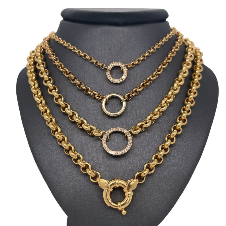 May include: Four gold chains with different link styles and diamond-encrusted circle pendants. The bottom chain has a large, round, gold clasp.
