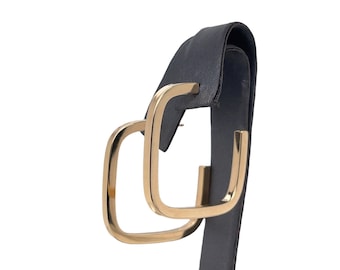 May include: A pair of gold square hoop earrings. The earrings are shown on a black earring display stand.