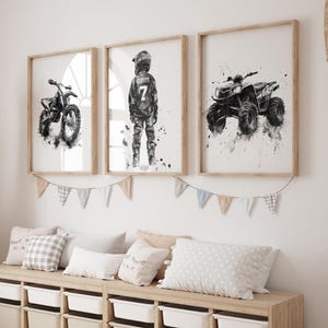 May include: Three framed watercolor prints of a motorcycle, a motocross rider, and an ATV. The prints are in neutral tones and are displayed above a storage bench with white bins. A woven giraffe and decorative pillows complete the room.