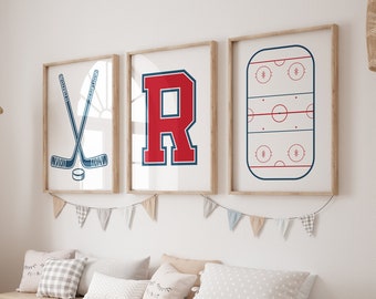 May include: A white wall with three framed prints. The prints feature a hockey stick and puck, a red letter R, and a hockey rink. A wooden bench with white storage bins sits in front of the prints.