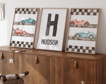 May include: Three framed prints with a checkered background and watercolor illustrations of race cars. The middle print features the letter "H" and the name "HUDSON" in black text.
