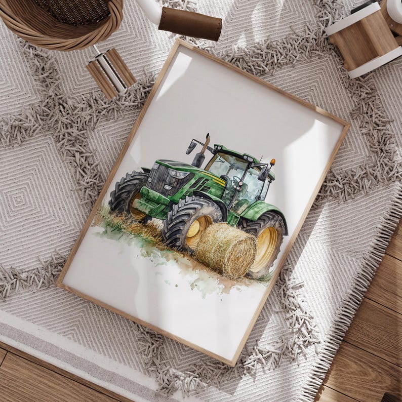 Może przedstawiać: Akwarela przedstawiająca zielony traktor z ż&oacute;łtymi kołami i belą siana. Grafika jest oprawiona w jasną drewnianą ramę. Obraz znajduje się na białej powierzchni z szaro-białym wzorzystym dywanem.
