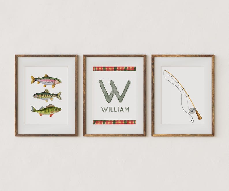 May include: Three framed prints with a fishing theme. The first print features three watercolor fish, a rainbow trout, a perch, and a bass. The second print features a watercolor letter W with the name William below. The third print features a watercolor fishing rod and reel.
