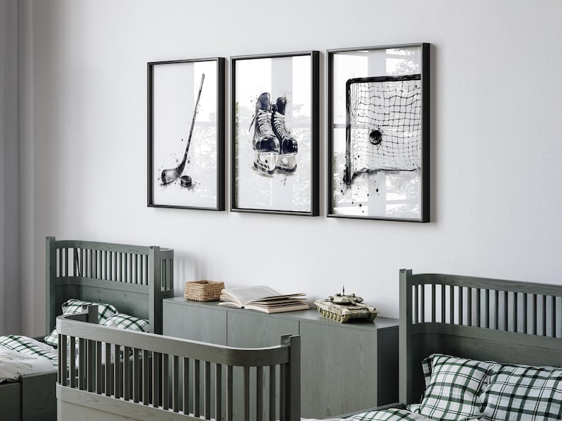 Pode incluir: Um conjunto de tr&ecirc;s quadros decorativos com ilustra&ccedil;&otilde;es a preto e branco em estilo aguarela de equipamento de h&oacute;quei no gelo, incluindo um stick de h&oacute;quei com um disco, um par de patins e uma baliza com um disco dentro da rede.