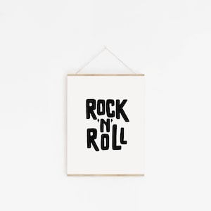 May include: A white framed print with black text that reads "Rock 'n' Roll".