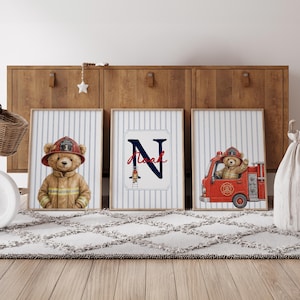 Peut inclure: Trois cadres muraux avec un fond à rayures verticales bleu clair et blanc. L'affiche de gauche montre un ours en peluche en uniforme de pompier. Celle du centre affiche une grande lettre N bleu marine avec le prénom Noah et un petit pompier. L'affiche de droite montre un ours en peluche conduisant un camion de pompiers rouge.