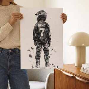 May include: A black and white watercolor-style art print depicting a motocross rider from behind. The rider wears a helmet, jersey with the name DAVIS and number 7, pants, and boots. The illustration features ink splatters and a white background.