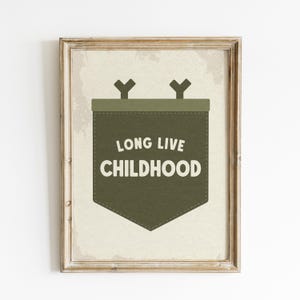 Może przedstawiać: Wydruk w ramie o estetyce vintage przedstawiający zielony baner z tekstem "Long Live Childhood". Baner ma dwa haczyki w kształcie litery Y u g&oacute;ry i spiczasty d&oacute;ł.