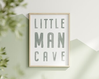 May include: A framed print with the text "LITTLE MAN CAVE" in a light green color on a white background.