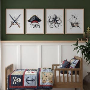 May include: Four framed watercolour prints with a pirate theme above a child's bed. The prints depict crossed swords, a pirate hat with the name "JAMES", an octopus, and a sailing ship. The bed has a pirate-themed quilt and pillows.