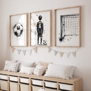 Puede incluir: Tres cuadros de pared con tem&aacute;tica de f&uacute;tbol. El cuadro de la izquierda muestra un bal&oacute;n de f&uacute;tbol, el central representa a un jugador con una camiseta con el n&uacute;mero 6 y el nombre Noah, y el de la derecha muestra una red de porter&iacute;a de f&uacute;tbol.