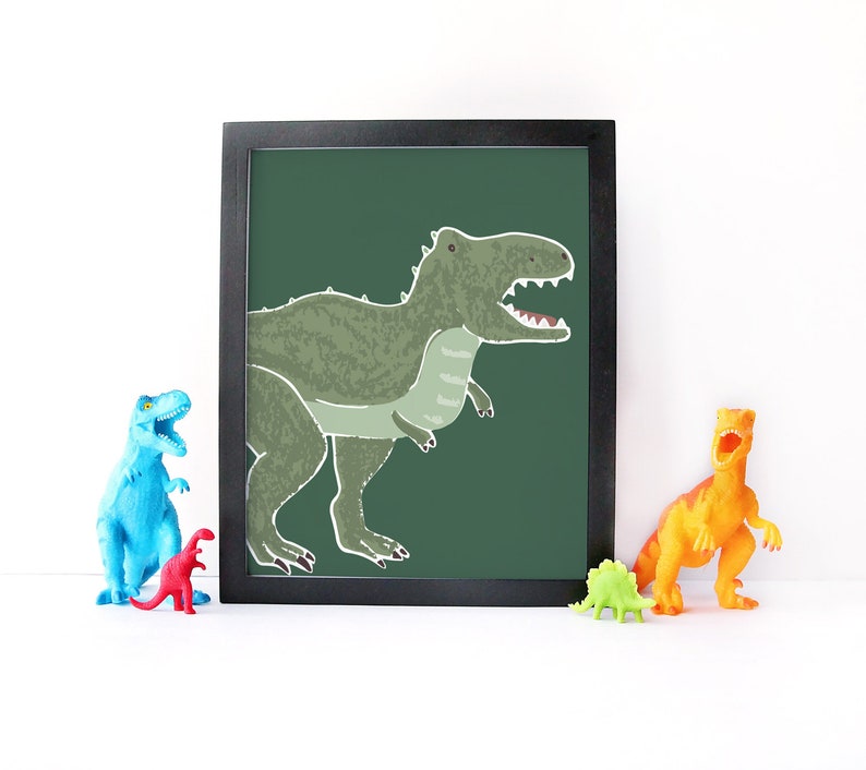 Op de afbeelding: Een ingelijst afdruk van een groene dinosaurus met een donkergroene achtergrond. De dinosaurus kijkt naar rechts en heeft zijn mond open. De afdruk is in een zwart frame.