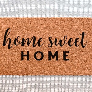 May include: A brown coir doormat with the text "home sweet HOME" in black lettering.