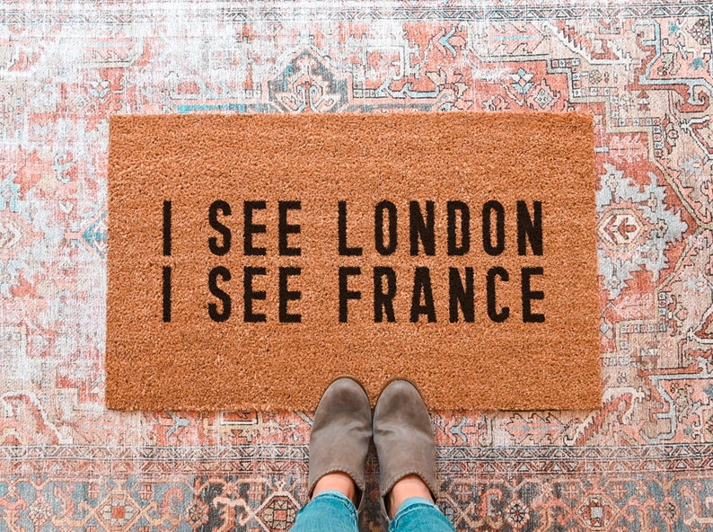 May include: A brown coir doormat with the text "I see London, I see France" in black lettering.